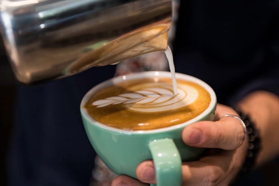man creating design in espresso foam